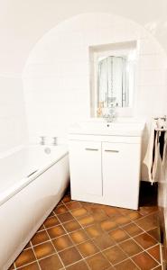 霍姆弗斯THE OLD WASH KITCHEN - Charming Character Cottage in Holmfirth, Yorkshire的白色的浴室设有浴缸和水槽。