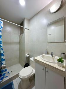 利马Apartamento Acogedor - BARRANCO的白色的浴室设有卫生间和水槽。