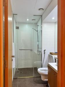 阿布扎比Luxury private sea view room的一间带玻璃淋浴和卫生间的浴室