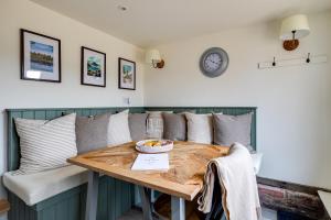 惠特彻奇Oak Tree Hideaway的餐桌、枕头和墙上的时钟