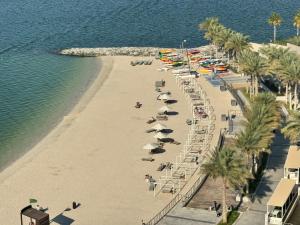 阿布扎比Luxury private sea view room的海滩上的人与遮阳伞景