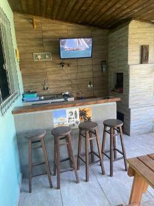 巴拉那州蓬塔尔Casa em Pontal do Paraná的厨房配有3把吧台凳和水槽