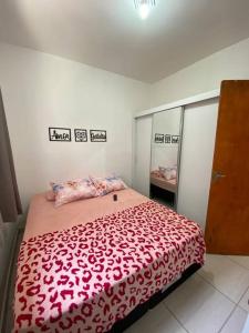 伊塔尼亚恩Promoção especial do mês de março em Itanhaém的一间卧室配有一张带红色毯子的大床