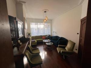 奥斯坦德Charmante Art Deco rijwoning的客厅配有沙发、椅子和桌子