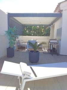 纳博讷36 2 L'air marin maison duplex grande terrasse的庭院里种植了白色长凳和盆栽植物