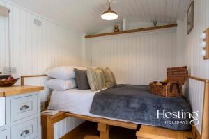 泰姆One Of A Kind Shepherds Hut With Incredible Views的一间卧室配有一张床、一张桌子和枕头