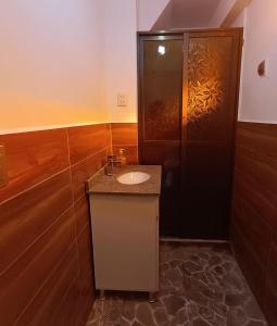 PeñasHostal Casona Don Ranulfo的一间带水槽和黑色门的浴室