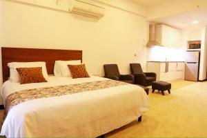 尼甘布Ocean Breeze Apartment Negombo, R 5, B16 Mina的酒店客房,配有一张床和两把椅子