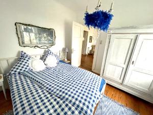 Klingbergromantische Ferienwohnung Sachsenhof 2的卧室配有蓝色和白色的格子床