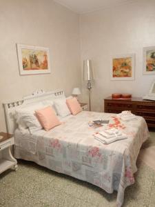 Castel LagopesoleLa Casetta Di Anna的卧室配有带粉红色枕头的大型白色床