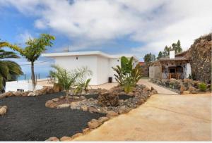 蒂哈拉费Casa Valista的白色的房子,带岩石的院子