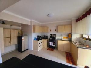 纳库鲁FH apartments opposite culture mambo的厨房配有黑冰箱和白色橱柜。