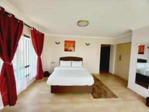 纳库鲁FH apartments opposite culture mambo的一间卧室配有大床和红色窗帘