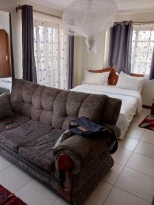 内罗毕Mvuli suites studio的客厅配有沙发和1张床