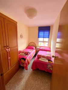 卡耐特蒂贝兰格Apartamento en la Playa Canet, muy cerca de Valencia的一间卧室设有两张床和窗户。
