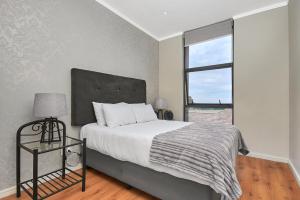 约翰内斯堡Executive 3 bed apartment with balcony & Executive 2 bed apartment in Sandton的一间卧室设有一张大床和一个窗户。