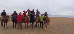 科奇科尔Son-Kul Northen yurt camp的一群人在海滩上骑马