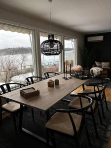 阿斯克尔Koslig bolig med sjøutsikt的餐桌、椅子和大窗户