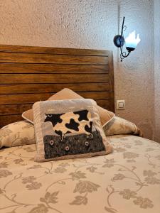 塞哥维亚Casa Rural Abuelo Regino的床上有奶牛枕头