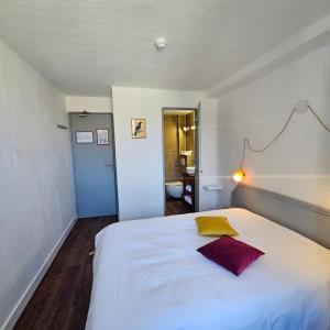 圣贝尔特朗德科曼日Hôtel Candide的卧室配有一张白色大床和黄色枕头