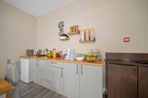 罗塞斯Queensferry Guest house的厨房配有白色橱柜和木制台面