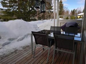 塔库沃里Viihtyisä huoneisto Tahkolla的雪地甲板上的桌椅