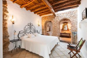 圣洛伦索巴拉菲Agroturismo Can Gall的卧室配有白色的床和石墙