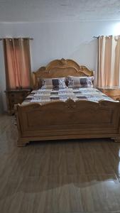 May PenVillas in A Gated Community的卧室铺有木地板,配有一张大型木质床。