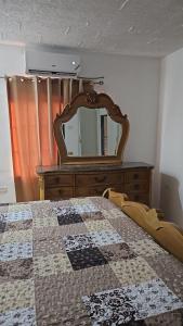 May PenVillas in A Gated Community的一间卧室配有梳妆台和一张带镜子的床
