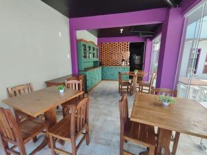 布卢梅瑙Pousada Casa da Maga - Centro的厨房配有木桌、椅子和紫色墙壁