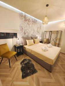 沃洛斯Volos Guesthouse Konstantina的一间卧室配有一张大床和一把椅子