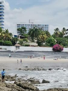 普拉亚科罗纳多Apartamento de playa con vista al mar en coronado的一群人,在海边