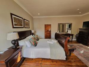 罗伯森Adderley House Guest Accommodation的一间卧室配有一张床和一张带台灯的桌子