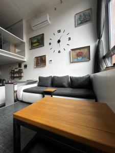 兹林1 bedroom loft apartment的客厅配有沙发和墙上的时钟