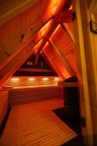 LeipeFließ Paradies mit Blockbohlensauna的阁楼间设有木地板和木制天花板。