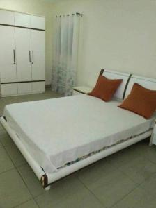 IvatoVilla SPIROU的卧室配有带橙色枕头的大型白色床