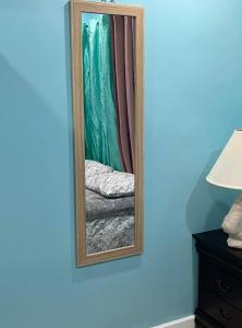 马尔斯港SanAndros Airbnb的一张镜子,一面在蓝色的墙壁上,一面在床边