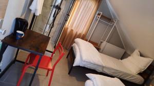 科隆Niehler Hotel的小房间设有一张床、一张桌子和椅子