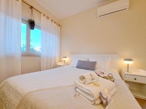 波尔蒂芒Villa Prana Guesthouse, Yoga & Ayurveda的卧室配有白色床和毛巾