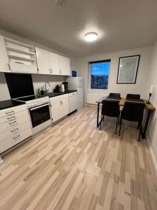 托尔斯港Apartment in Tórshavn.的厨房配有白色橱柜和桌椅