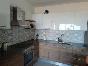 纳杜尔Gozo Spacious 3 Bathroom Apartment的厨房配有木制橱柜和水槽。