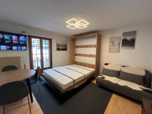 莱斯克伦斯Cosy studio for 4 near ski lift, CRETES B24的一间卧室配有一张床、一张沙发和一张桌子