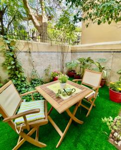 卡拉奇Mohalla Rooftop Retreat的草坪上摆放着一张木桌和两把椅子