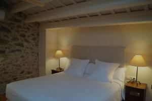FontanillesMas Vermell的一间卧室配有一张带两盏灯的大型白色床。