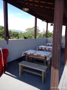 阿帕雷西达Pousada Mundo Novo的庭院设有两张桌子和一张长凳
