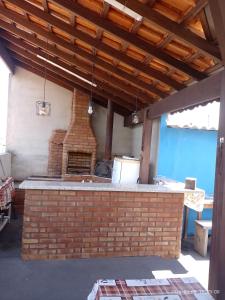 阿帕雷西达Pousada Mundo Novo的一个带砖比萨烤箱的户外厨房
