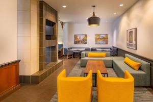 麦迪逊麦迪逊/市中心凯悦嘉轩酒店的客厅配有沙发、桌子和黄色椅子