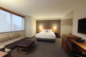 皇后区法拉盛/拉瓜地亚机场凯悦酒店的酒店客房,配有床和沙发