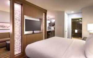 波特兰波特兰/市中心Hyatt house酒店的卧室配有白色的床和平面电视。