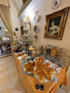 都灵Ai Savoia B&B - Guest House的餐桌上的自助面包和糕点